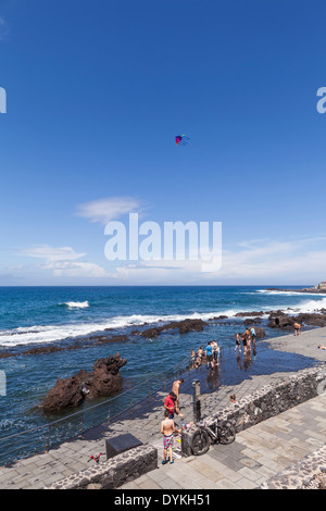 Schwimmer und Touristen spielen auf dem Fels-Pools an der Playa de Jaquita in Alcala, Teneriffa, Kanarische Inseln, Spanien Stockfoto