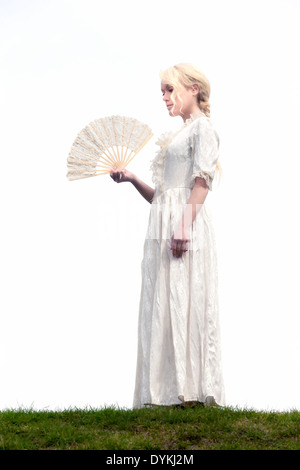 eine Frau in einem weißen Periode Kleid mit Spitze fan Stockfoto