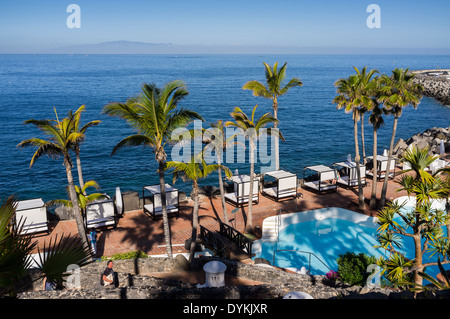 Direkt am Meer Poolbereich Sonnen und Palmen im Jardin Tropical Hotel in Las Americas, Teneriffa, Kanarische Inseln, Spanien. Stockfoto