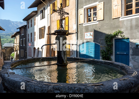 Ein Brunnen und Schaufenster in dem mittelalterlichen Dorf von Conflans, Teil der Gemeinde von Albertville Frankreich in der Savoie. Stockfoto