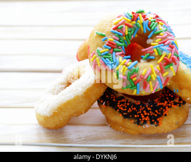 Donuts mit bunten Glasur auf dem hölzernen Hintergrund Stockfoto