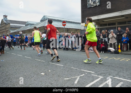 Läufer erreichen die ungefähre halber Strecke entlang der Market Street, Altrincham in 2014 Manchester Marathon. Stockfoto