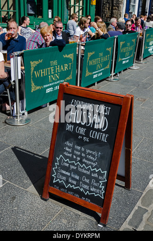 Kunden, die einen Drink in der Frühlingssonne im White Hart Inn in der Grassmarket, Edinburgh. Stockfoto