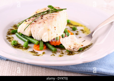 Kabeljaufilet mit grünen Bohnen, Erbsen, Petersilie, Olivenöl Stockfoto