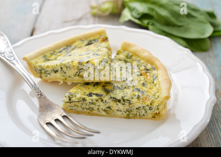 Traditionelle französische Quiche-Torte mit Spinat und Käse auf weißen Teller Stockfoto