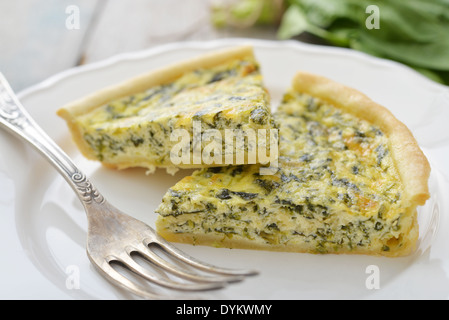 Traditionelle französische Quiche-Torte mit Spinat und Käse auf weißen Teller Stockfoto