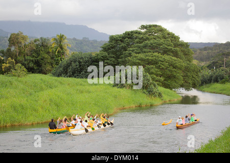 Frauen paddeln mit Outrigger-Kanus auf dem Hanalei River am Nordufer von Kauai. Stockfoto
