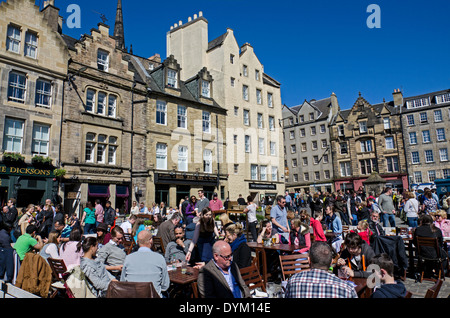 Touristen und Einheimische genießen einen sonnigen Frühling Nachmittag im Grassmarket, Edinburgh, Schottland, UK. Stockfoto