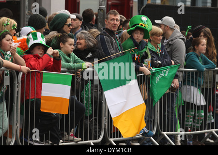 Menschen halten irische Trikolore Flaggen auf der St. Patricks Day Parade in Dublin Stadtzentrum Stockfoto