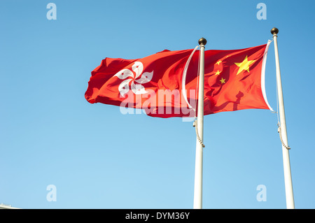 Hong Kong und China Nationalflaggen vor einem blauen Himmel fliegen Stockfoto