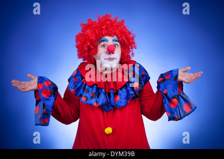 Überrascht Clown auf blauem Hintergrund. Professionelle Studiobeleuchtung Stockfoto