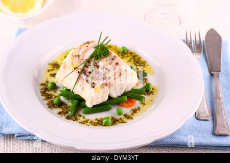 Kabeljaufilet mit grünen Bohnen, Erbsen, Petersilie, Olivenöl und Wein Stockfoto