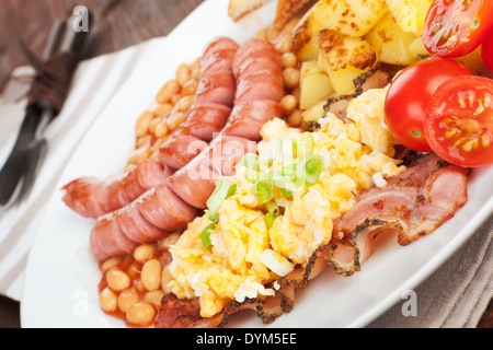 Leckeres englisches Frühstück, rustikalen Stil. Bohnen, Würstchen und Rührei und Tomaten. Guten Morgen-Konzept. Stockfoto