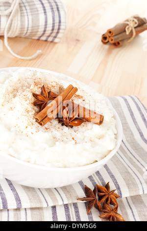 Kulinarischen Milchreis mit Zimt und Sternanis in weißen Schale garnieren. Leckeres vegetarisches Essen. Stockfoto