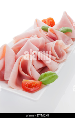 Leckere Schinken Teller mit Tomaten und frischem Basilikum isoliert auf weißem Hintergrund. Stockfoto