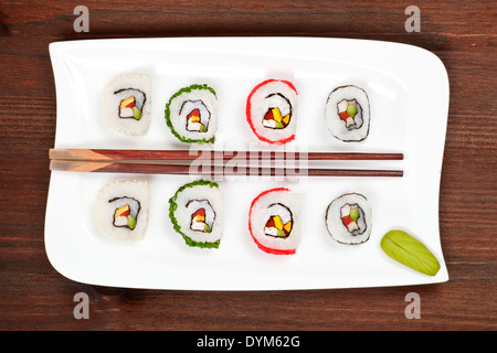Makizushi. Leckere Maki Sushi-Rollen auf weißen Teller mit Stäbchen und Wasabi. Maki Stockfoto