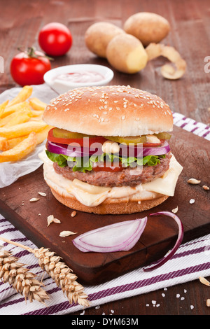 Traditionellen Hamburger auf dunklem Holz. Stockfoto
