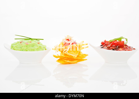 Leckere Nachos mit Guacamole und Tomatensauce in Schalen isoliert auf weißem Hintergrund. Stockfoto