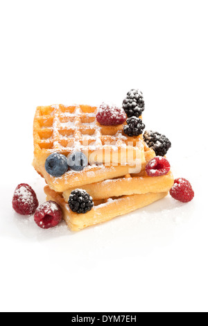 Waffel-Haufen mit Himbeeren, Heidelbeeren und Brombeeren isoliert auf weißem Hintergrund. Kulinarischen Süßspeise. Stockfoto