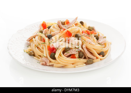 Leckere Pasta mit Thunfisch, Kapern und Gemüse auf weißen Teller auf weißem Hintergrund. Kulinarisches Essen. Stockfoto