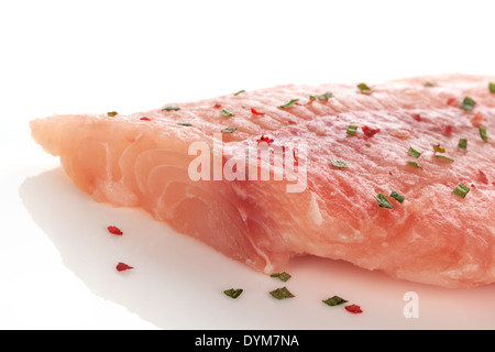 Gefrorenen Fisch filetieren und Detail mit bunten Gewürzen und Kräutern auf weißem Hintergrund. Kulinarischen Meeresfrüchte essen. Stockfoto