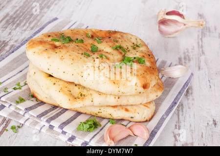 Luxuriöse Naan Fladenbrot Stack auf weißem Holz strukturierten Hintergrund. Kulinarischen asiatischen Brot essen Konzept. Stockfoto