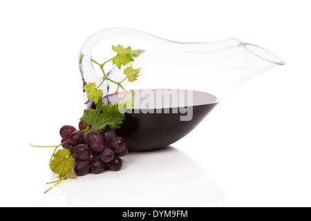 Rotwein in luxuriösen Karaffe mit roten Trauben, Weinlaub und Weinkorken isoliert auf weißem Hintergrund mit Reflexion. Stockfoto