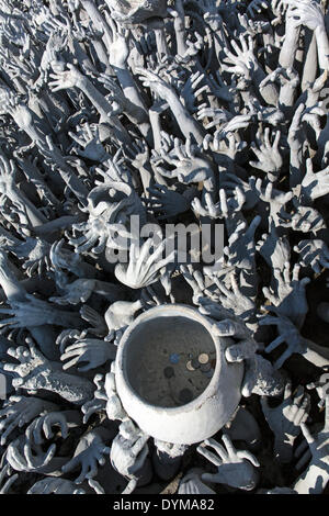 Darstellung der Hölle, Hände bittet um Hilfe und eine Bettelschale am Wat Rong Khun, Brücke zum Eingang des weißen Tempels, von Stockfoto