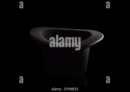 Schwarzen Zylinder auf schwarzem Hintergrund isoliert. Klassische Herrenmode. Stockfoto