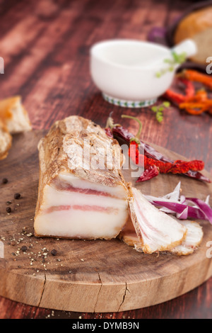 Traditionelle Speck essen. Stück der großen fetten Speck, Zwiebel, Kräuter auf hölzernen Hintergrund. Kulinarisches leckere Fleisch zu essen. Stockfoto