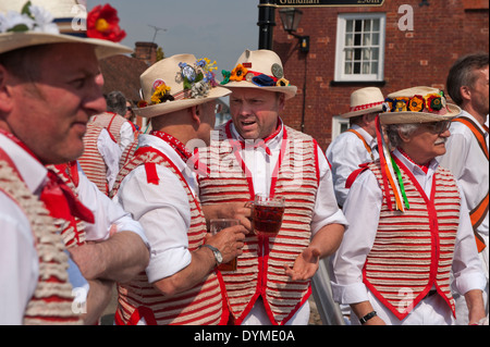 Thaxted Morris Männer führen in rot und weiß und Devil es Dyke Morris in der Stierkampfarena, Thaxted, Essex, England, auf eine herrliche Sonne Stockfoto