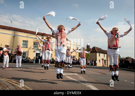 Thaxted Morris Männer führen in rot und weiß und Devil es Dyke Morris in der Stierkampfarena, Thaxted, Essex, England, auf eine herrliche Sonne Stockfoto