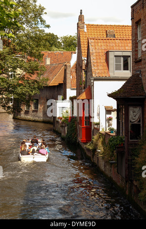 Touristen auf einer Bootsfahrt, vorbei an den mittelalterlichen Häusern am Dijver Kanal, Brügge, Belgien Stockfoto