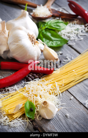 Traditionelle Zutaten der italischen Küche - Pasta, Knoblauch, Paprika, Basilikum und gemaserte Parmigiano. Selektiven Fokus. Stockfoto