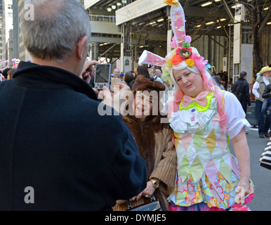 Touristen in New York Easter Parade auf der Fifth Avenue posieren mit einer Frau in einem Bunny Outfit. Stockfoto