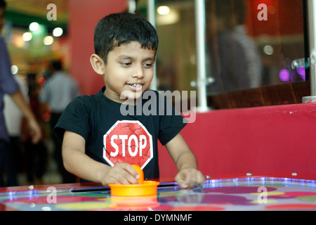 Indische Kleinkind spielen Air-hockey Stockfoto