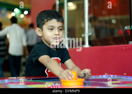 Indische Kleinkind spielen Air-hockey Stockfoto