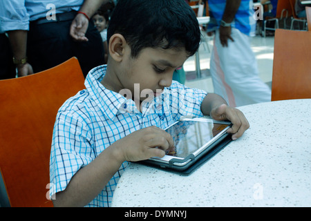 Indischen Jungen spielen auf dem ipad Stockfoto