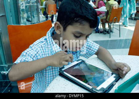 Indischen Jungen spielen auf dem ipad Stockfoto