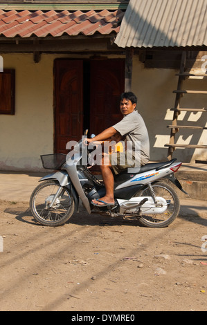 Vertikale Porträt eines Vaters mit seinem kleinen Sohn in den Fußraum ein Briefpapier Motorrad in Laos Stockfoto