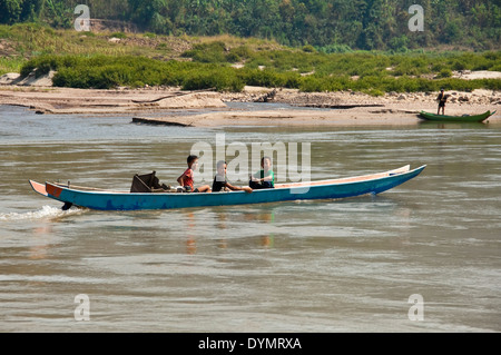 Horizontale Ansicht von 3 jungen Lao ein langes Boot entlang des Mekong Flusses fahren. Stockfoto