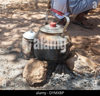 Traditionellen Wasserkocher am Lagerfeuer in der Wüste mit Beduinen Mann Stockfoto