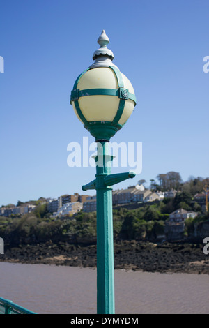 Ein Detail eines der Lampen auf Clevedon Pier, North Somerset, England, UK, mit Clevedon Stadt im Hintergrund Stockfoto