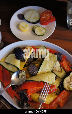 Platte mit gebratenem bunten Gemüse mit Löffel und Gabel Stockfoto