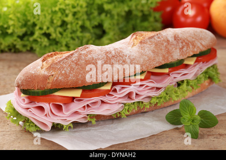 Baguette mit Schinken, Käse, Tomaten, Salat und Gurke Stockfoto