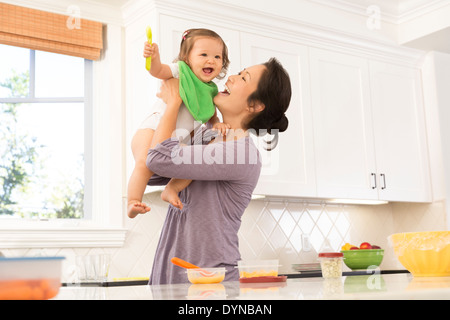 Mutter mit Babymädchen in Küche Stockfoto