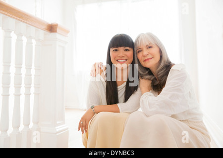 Mutter und Tochter umarmt auf Treppe Stockfoto