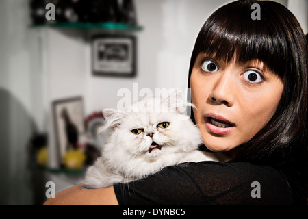 Überrascht Frau Holding Katze Stockfoto