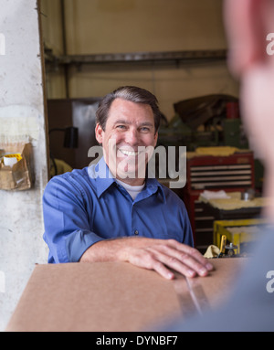 Kaukasische Arbeiter lächelnd in Lager Stockfoto