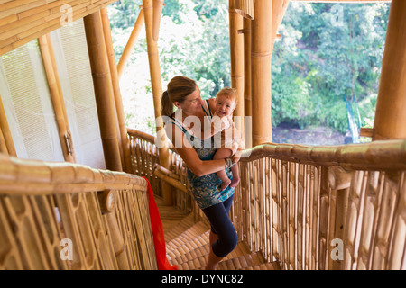 Kaukasische Mutter Baby Treppe hinauf tragen Stockfoto